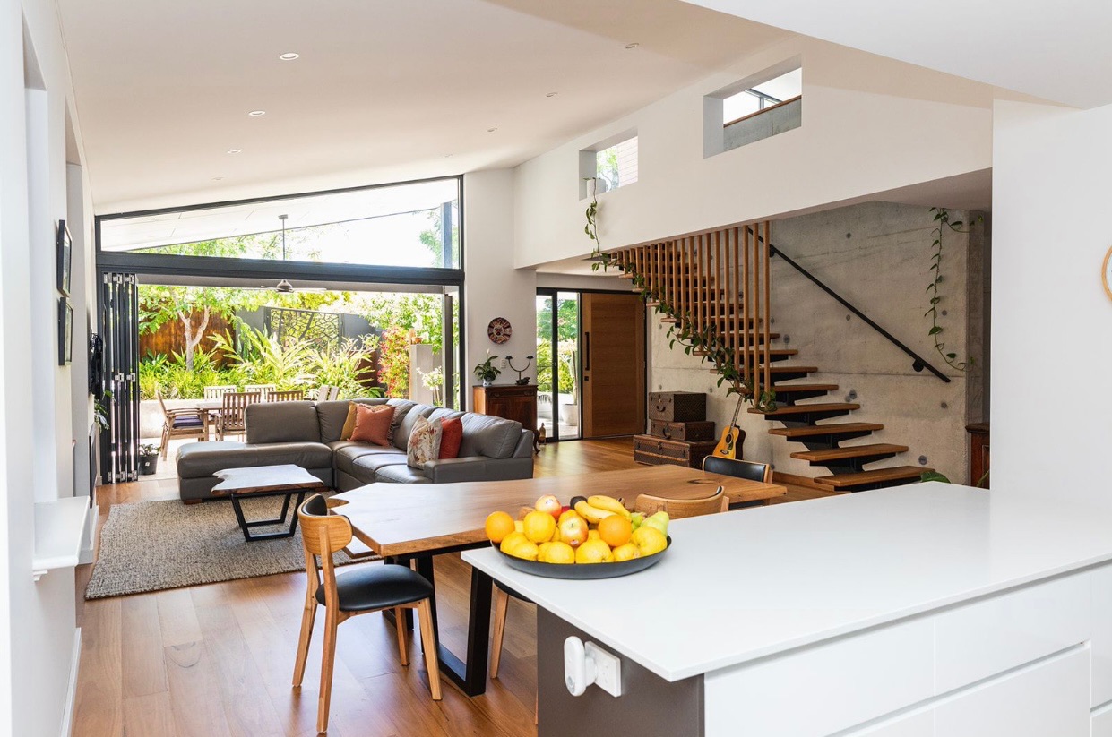 Bright open-plan living space with kitchen island and garden outlook